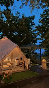 a white tent with a table and an umbrella at Il Bosco di Paolo - Glamping in Sestola