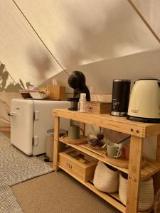 a kitchen with a table with a microwave and a refrigerator at Il Bosco di Paolo - Glamping in Sestola