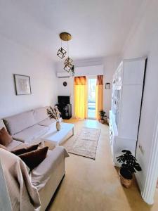 uma sala de estar com um sofá e uma mesa em Best View Katechaki Bridge Metro em Atenas
