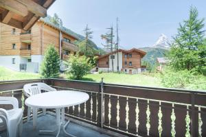 a patio with a table and chairs on a balcony at Haus Bärgbach in Zermatt