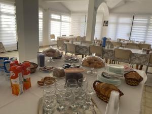 a table with glasses and plates of food on it at B&B Family OSTOJIĆ in Međugorje +7 photos