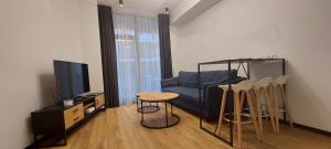 - un salon avec un canapé, une table et des tabourets dans l'établissement Graf Zeppelin Apartment, à Pärnu