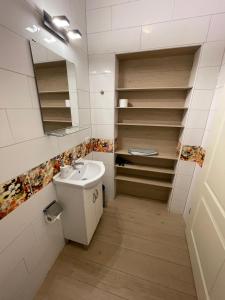 baño con lavabo, espejo y estanterías en Romantik Appartament, en Potenza Picena
