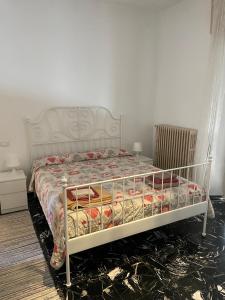 Un dormitorio con una cama blanca con flores. en Romantik Appartament, en Potenza Picena