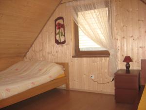 a small bedroom with a bed and a window at Domek Czerwony Kapturek in Płocice