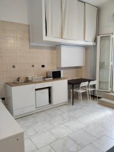 eine Küche mit weißen Schränken sowie einem Tisch und Stühlen in der Unterkunft Casa Vacanze Arturo in Bari