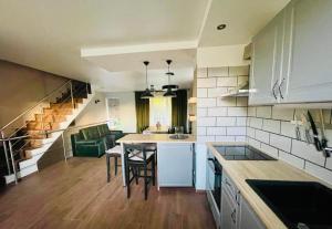 eine Küche mit einem Tisch und Stühlen sowie eine Treppe in der Unterkunft Rooms4Rent Cottage in Klaipėda