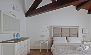 a white bedroom with a bed and a dresser at La Casa di Filippo in Palermo