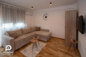 uma sala de estar com um sofá e duas mesas em Petković apartmani STUDIO32 em Jagodina