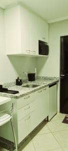 南雅拉瓜的住宿－Quarto Jaraguá/São Luís，白色的厨房配有水槽和微波炉