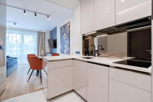 a kitchen with white cabinets and a orange chair at Sunhill Residence 5* suite Castle district in Budapest