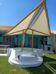 a pavilion with a large beige canopy in a yard at ASAS DEL MAR - SUITES in Canoa Quebrada