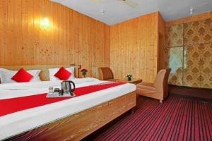 una camera d'albergo con un grande letto con cuscini rossi di OYO Hotel Jay Palace a Srinagar