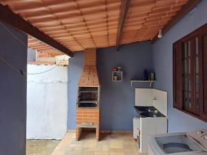 a kitchen with a brick oven in a blue wall at Casa Aconchegante in Paraty