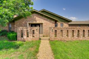une maison en briques avec une porte et une cour en herbe dans l'établissement Serene Abilene Oasis on 4 Secluded Acres!, à Abilene