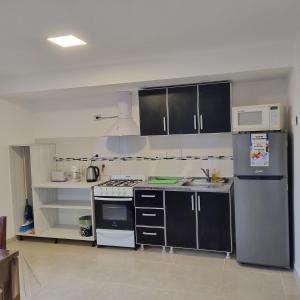 uma cozinha com armários e electrodomésticos a preto e branco em Laguna Encantada dpto 2 em Ushuaia