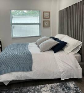 a bedroom with a bed with pillows and a window at Roy's guest house in Orlando