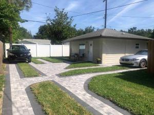 a house with a car parked next to a driveway at Roy's guest house in Orlando