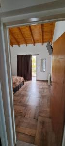 een kamer met een bed en een houten vloer bij Complejo Boulevard Plottier in Plottier
