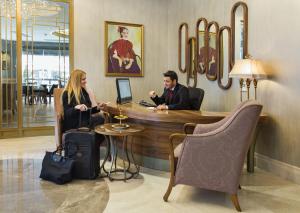a man and woman sitting at a bar in a hotel lobby at Hotel Morione & Spa Center in Istanbul