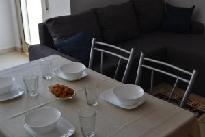 a table with plates and cups and a bowl of food at Studio Apartment Golem in Golem +1 photo