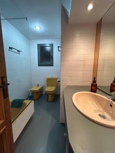 uma casa de banho com um lavatório e um WC em La Perla em Palamós