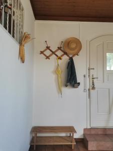 Habitación con puerta, sombrero y banco en Mészi Vendégház, en Zalacsány