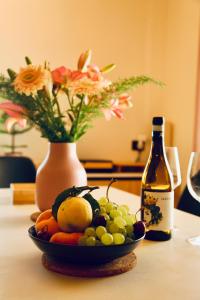uma taça de fruta numa mesa com uma garrafa de vinho em Paradisea Rocco's Villa em Taormina