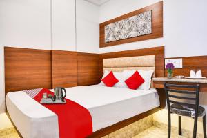 a bedroom with a bed and a table and a chair at Classic Court in Patna