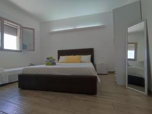 ein Schlafzimmer mit einem großen Bett und einem Spiegel in der Unterkunft B&B DreAm Porto Cesareo in Porto Cesareo