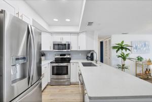 a kitchen with white cabinets and a stainless steel refrigerator at 6415 Midnight Pass #608 in Siesta Key