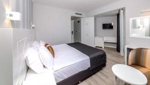 a hotel room with a bed and a table and chairs at Motto Premium Hotel&Spa in Marmaris