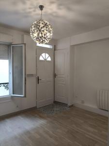 une pièce vide avec une porte et un lustre dans l'établissement Paris 12 30m² quiet comfortable studio apartment, à Paris