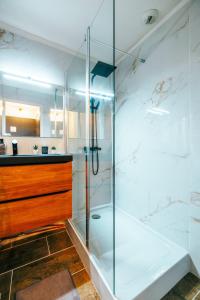 eine Glasdusche im Bad mit Waschbecken in der Unterkunft Mystic Mountain Apartment Chamrousse in Chamrousse