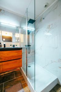 W łazience znajduje się szklana kabina prysznicowa i umywalka. w obiekcie Mystic Mountain Apartment Chamrousse w mieście Chamrousse