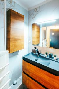 łazienka z umywalką i lustrem w obiekcie Mystic Mountain Apartment Chamrousse w mieście Chamrousse +27 zdjęć