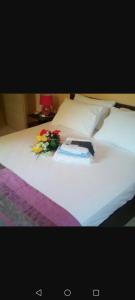 a bed with a book and flowers on it at Villa tolis in Mádhena