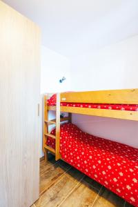 sypialnia z 2 łóżkami piętrowymi i czerwoną pościelą w obiekcie Mystic Mountain Apartment Chamrousse w mieście Chamrousse