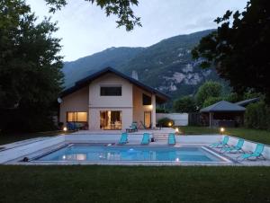 a house with a swimming pool in the yard at Villa Armonia, piscine chauffée, jacuzzi et jardin à 5mn du lac d Annecy in Doussard