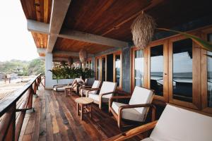 a balcony with chairs and tables and the ocean at Naked Hotel Zipolite -Adults Only- in Zipolite