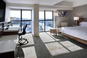 Delta Hotels by Marriott Burnaby Conference Centre في برنابي: غرفة في الفندق بها سرير ومكتب ومكتب