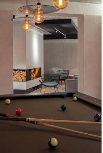 a living room with a pool table and a fireplace at Luxuriöse Berg-Ferienwohnungen-Andermatt in Andermatt