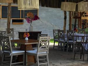 eine Terrasse mit Tischen und Stühlen mit Blumen darauf in der Unterkunft Entre Palmeras in Bocapán