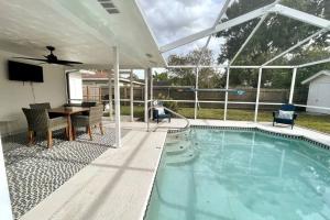 タンパにあるStunning Heated Pool & Spa House Blocks to Midtownのスイミングプール(テーブル、天井ファン付)