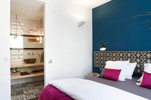una camera con un letto bianco e una parete blu di Apartment Vila Olímpica Barcelona next to beach & garden a Barcellona