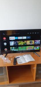 a television on a wooden table with a remote control at Oława Jodłowa in Oława
