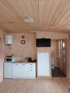 kuchnia z białymi urządzeniami i drewnianym sufitem w obiekcie Zajazd Ponikiew - Noclegi Wadowice w Wadowicach