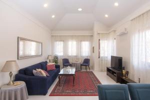 un soggiorno con divano blu e TV di Apartment ADA a Visoko