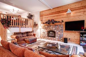 uma sala de estar com um sofá e uma lareira de pedra em Stunning Multi-Level Home near Hiking Trails and Main St, with PRIVATE Hot Tub WP33 em Breckenridge