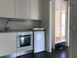 a kitchen with white cabinets and a stove and a dishwasher at Kotoisa Parkkipaikallinen Kaksio Kangasalan Keskustassa in Kangasala